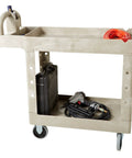Heavy Duty Two Shelf Utility Cart With Lipped Shelves And Ergonomic Handle, 500 Lb Capacity, Beige in warehouse setting.