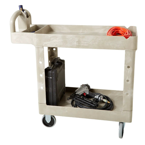 Heavy Duty Two Shelf Utility Cart With Lipped Shelves And Ergonomic Handle, 500 Lb Capacity, Beige in warehouse setting.