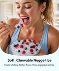 Woman enjoying soft, chewable nugget ice from a bowl with berries, showcasing premium_countertop_nugget_ice_maker_rapidly_chills_your_kitchen_with_up_to_35_pounds_of_smooth_crushed_ice_daily_featuring_a_lightning_fast_five_minute_production,_zero_hassle_self_cleaning,_and_game_changing_reliable_build_for_every_busy_american_househo.