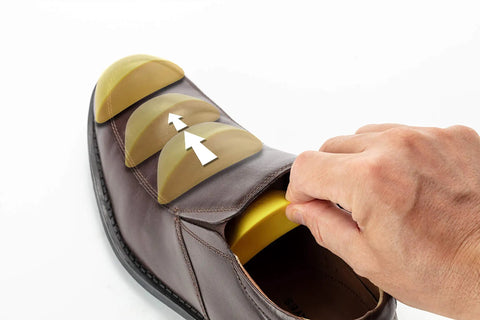 Memory Foam Shoe Inserts For Big Shoes Fit Unisex Toe Box Fillers being adjusted in brown shoe for wide feet comfort