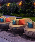 Outdoor Metal Patio Torches Set Ideal For Deck Patio Backyard Outdoor Parties And Weddings Includes Fiberglass Wick And Snuffer Cap 4 Pack Long Lasting Five Hour Flame With Citronella Oil Not Included illuminating a patio area with chairs and cushions.