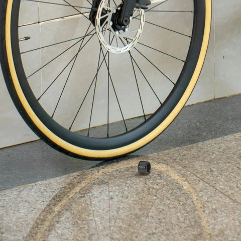 Aluminum Alloy Bicycle Axle Cap for Front and Rear Wheel Hubs shown next to a bicycle wheel for easy install and secure fit.