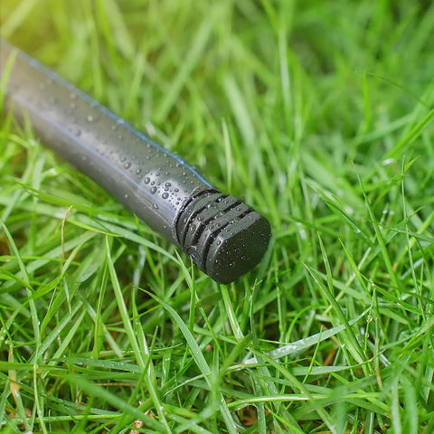 Wet black end cap from DIY Ready 1/2 Inch Drip Irrigation End Cap Kit With 15 Barbed End Plugs on green grass