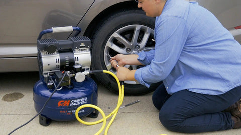 Image of a person using a 17 Piece Compressor Inflation Kit With Blow Gun, Air Chucks And Inflation Needles to inflate a car tire.