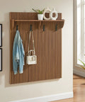Mid Century Modern Fluted Walnut Wall Mount Coat Rack Panel With Roomy Shelf And Hella Sturdy Hooks For Entryway Hallway Mudroom Sweet Wall Organized Storage Setup With Groovy Wood Grain Details featuring jackets and bags hung neatly.