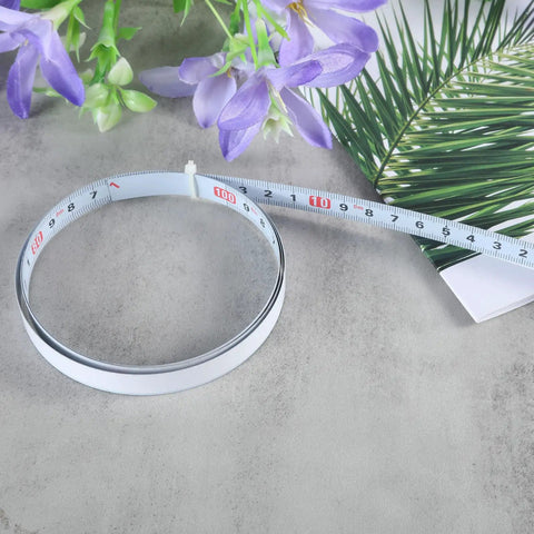 Precision Folding Tape Measure And Measuring Ruler Kit For Tough Woodworking Jobs High Visibility White Finish laid out with flowers.