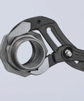Close-up of 16 Inch XL Red Self Locking Water Pump Pliers With 27 Adjustment Positions gripping a metal pipe fitting.