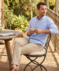 Man sitting on bistro chair with beige 15 inch round tufted seat pad on a patio