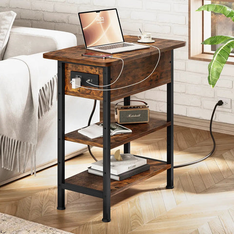 End Table With Charging Station And USB Ports, Flip Top Side Table With Two USB Ports And One AC Outlet, Three Tier Small Storage Table For Small Spaces, The Ultimate Space Saver For Your Living Room Or Bedroom, Brown Finish. Image shows brown finished table in living room setting with laptop on top.