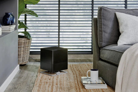 Black evaporative humidifier in a cozy living room setting with natural light and decor items