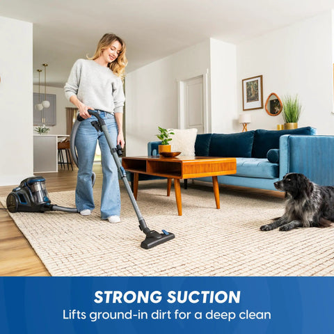 Using Quiet Bagless Canister Vacuum With Kickass Suction For Whole Home Cleaning on carpet, woman vacuuming living room.