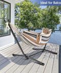 550 Pound Capacity Double Hammock With Stand In Desert Stripe Portable Bag Included Ultra Comfortable 60 By 80 Inch Cotton Polyester Bed Easy Setup For Two And Backyard Chill on balcony with person relaxing in it.