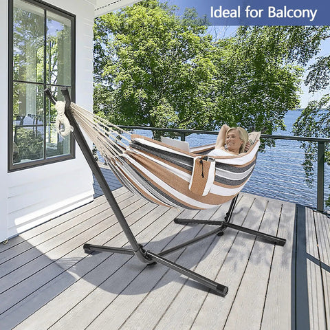 550 Pound Capacity Double Hammock With Stand In Desert Stripe Portable Bag Included Ultra Comfortable 60 By 80 Inch Cotton Polyester Bed Easy Setup For Two And Backyard Chill on balcony with person relaxing in it.