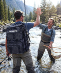Two men fishing with Fishing Tackle Backpack With Rod Holders For Anglers 42L Waterproof Gear Bag in a river.