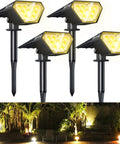 Solar Spot Lights Outdoor 4 Pack, 700 Lumen IP67 Waterproof shining on a garden with trees and patio, Warm White 3000K illumination