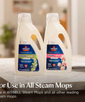 Heavy Duty Steam Mop With 12 Inch Sweeping Path For Hardwood And Tile Floors Featuring Built In Scrubber And Variable Steam Controls image of two bottles of steam and refresh solution on a table.