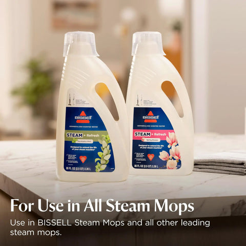 Kick Dust And Grime To The Curb With This All In One Vacuum And Steam Mop Featuring Digital Controls Powerful Cyclonic Suction And Deep Sanitizing Power For Quick Hardwood And Tile Floor Maintenance. Two Bissell steam mop cleaning solutions on a countertop.
