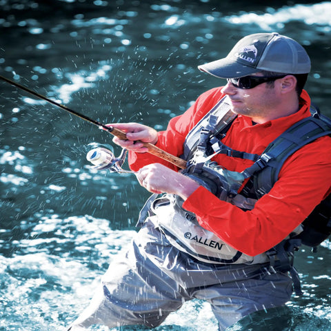 Angler wearing Ultra Lightweight Fly Fishing Vest With 14 Pockets And Front Zip Storage Olive Green in a river