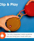 Two hands holding Clip 3 Fiesta Red Portable Bluetooth Speaker With Up To 10 Hours Of Playtime, Waterproof And Durable, Built In Carabiner Clip