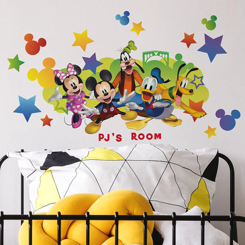 Disney Mickey And Friends Giant Peel And Stick Wall Decals With Personalization 116 Piece Set Includes Alphabet Letters For Custom Name Removable And Repositionable No Residue On Smooth Surfaces Great For Kids Rooms displayed above a bed