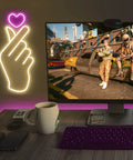 Finger Heart Neon Sign In Pink And Warm White For Bedroom And Game Room LED Light Hand Gesture Decor For K Drama And K Pop Fans Wall Decor Gift For Fans Vibe on a wall near a gaming setup, showing the hand gesture glowing brightly.