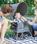Go With Me Venture Portable Toddler Chair On The Go with sun canopy in grey, showing family using chair outdoors, folds flat in carry bag