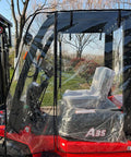 All Weather Forklift Cab Enclosure Cover With Heavy Duty UV Protection And Waterproof Vinyl Universal Fit For Forklifts Up To 6000 Lb Easy Zip Access Keeps Cold Air Rain Snow Out on a red forklift