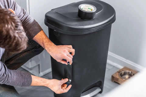 Person applying Max Strength Duct Tape Heavy Duty All Weather Waterproof Bond One Roll 1.88 Inch By 35 Yards Black to trash bin