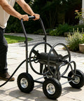 Garden Hose Reel Cart With 250 Ft Capacity, 10 Inch Pneumatic Tires, Powder Coated Steel Frame being pushed on patio