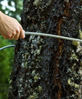 Hand holding Beefy Five Millimeter Galvanized Zip Line Cable For Backyard Fun Heavy Duty 131 Feet Wire Rope with tree in background