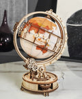 Illuminated Globe 3D Wooden Puzzle With Stand For Adults 180 Piece Build Built In LED Model Kit Cool Hobby Gift Home Decor Dorm Room Accent Relaxing Night Light on a marble table.