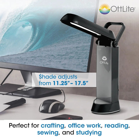 Folding Task Lamp With Multi Position Shade Portable Desk Light For Your Desk Setup Home Office Low Heat And Low Glare Fold Up Design With Handy Handle Fits Desks And Workstations White Finish on a desk setup with computer screen.