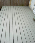 Wood deck with All In One Deck Stain And Sealer With UV Protection In A Solid Gray Finish For Wood Decks Fences And Siding, shown with potted plants