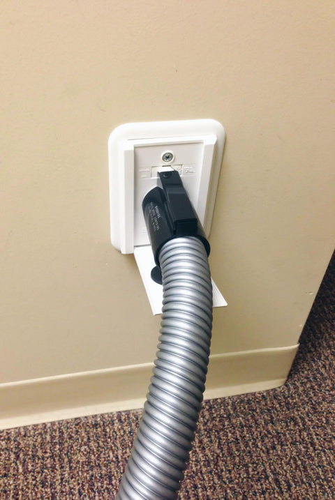 35 Ft Direct Connect Electric Central Vacuum Hose with Flush Handle attached to wall hanger, showcasing flush mount connection.