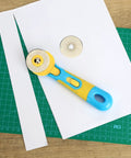 45mm Rotary Cutter Kit With One Extra Blade, Ergonomic Handle, A Real Workhorse With Ultra Sharp Steel Blades For Precise Fabric, Scrapbooking And Craft Cutting, Easy Grip, Smooth Cuts, Great For Quilting And DIY Projects. 45mm rotary cutter on paper and cutting mat