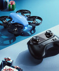 Mini Drone For Kids And Beginners With 3 Batteries, Indoor RC Quadcopter next to remote control on blue surface with gifts