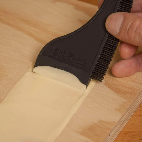 Applying glue with Non Stick Wood Glue Brush Silicone Applicator Kit with Comb Squeegee on wood surface.
