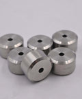 Six silver aluminum spacers with central holes, front view