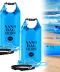 2 Pack Sand Anchor Bags 10L displayed with adjustable straps and ropes on a beach near a kayak float.