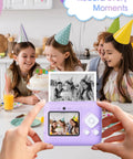 Children at a party enjoying cake with instant print camera showing photo; 12 Roll Kids Camera Paper Roll Refills Two Point Two Inch By 20 Foot Thermal Paper For Instant Print Cameras And Mini Sticker Printers White Premium Photo Paper Each Roll Yields 75 To 90 Photos.