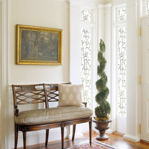 Self-Adhesive Privacy Glass Window Film In Bamboo White Pattern, 17 By 78 Inch Roll on tall windows by a bench in a home setting.