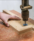uxcell 90mm Forstner drill bit, blue/gray tungsten carbide, mounted in drill chuck cutting into wood block