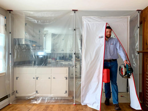 ZipDoor ZDM Magnetic Door Kit in use, self-closing barrier with man exiting, white polyester, 48x87 inches for dust containment.