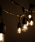 Beefed-Up 100 Foot Outdoor Commercial String Lights With E26 Suspended Sockets, glowing S14 11W bulbs hanging in darkness