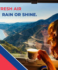 Person holding coffee cup by window with mountain and coastal view, text reads 'Fresh Air Rain or Shine'.