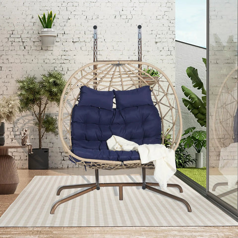 Double Swing Egg Chair With Stand For Patio And Balcony, dark blue cushions, two person rattan wicker basket, outdoor scene.