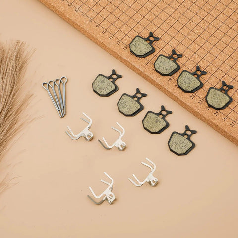 Four Pairs Bike Brake Pads Kit With Pins And Springs For Mountain Bikes on a grid background, showing pads, pins, and springs