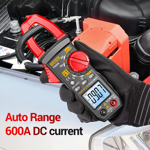 User holding All-In-One Digital Clamp Meter Multimeter For AC And DC Current And Voltage NCV Capacitance Resistance Diodes Continuity Frequency Backlit LCD 4000 Counts Handy Pro-Grade Electrician Tool For Quick Troubleshooting next to car engine