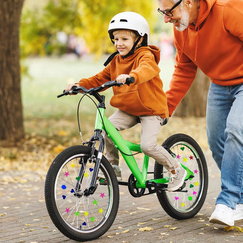Boy on a green bike with 180 pieces colorful bike wheel spoke beads clips for kids bicycle spoke decorations outdoors