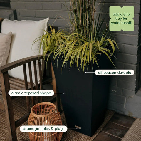 Indoor Outdoor Taper Planter Set Of 2 Dope 30 Inch Black Plastic Resin Planters beside a chair with decorative grass.